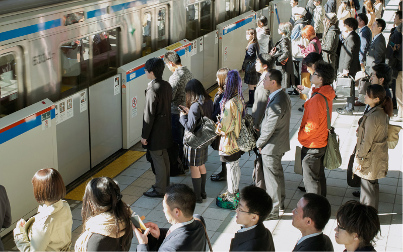 Passeggeri in fila ordinata alla metropolitana in Giappone: esempio di rispetto e organizzazione nei trasporti pubblici