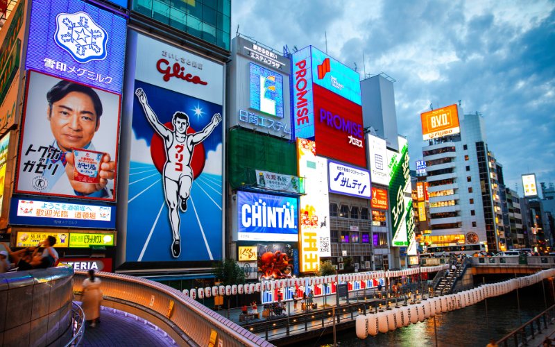 Insegne luminose a Dotonbori, Osaka: il famoso Glico Man e la zona dello shopping serale in Giappone

