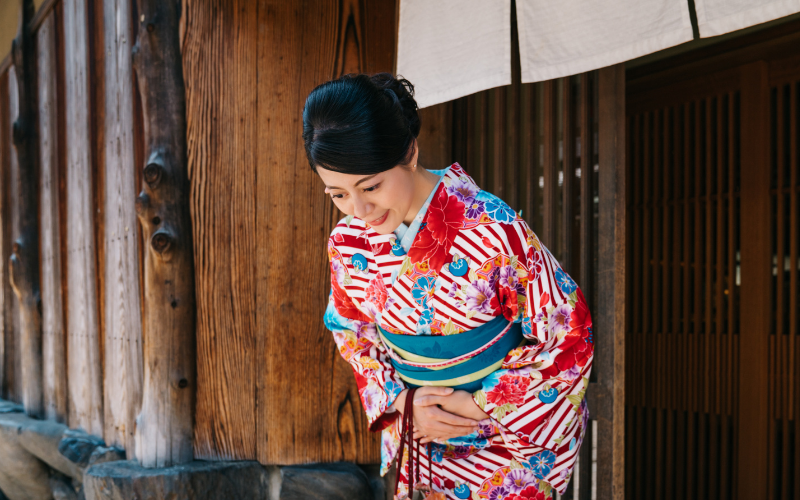 Donna giapponese in kimono che si inchina: gesto tradizionale di rispetto e cortesia in Giappone
