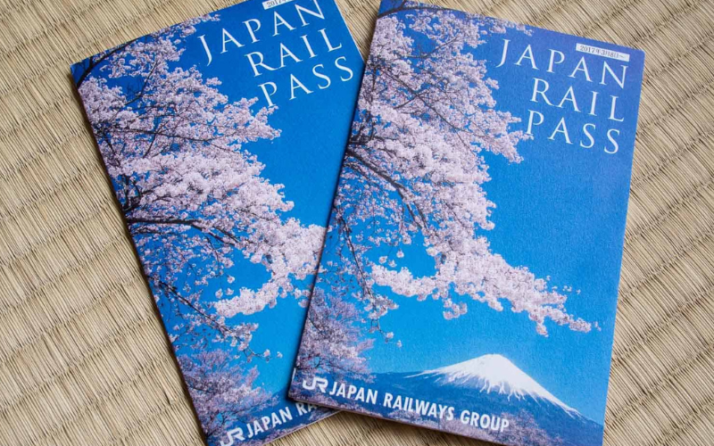 Due Japan Rail Pass con copertina raffigurante fiori di ciliegio e Monte Fuji, su tatami giapponese