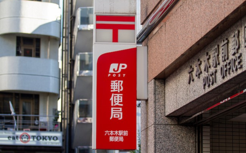 Insegna di un ufficio postale JP Post vicino alla stazione di Roppongi a Tokyo
