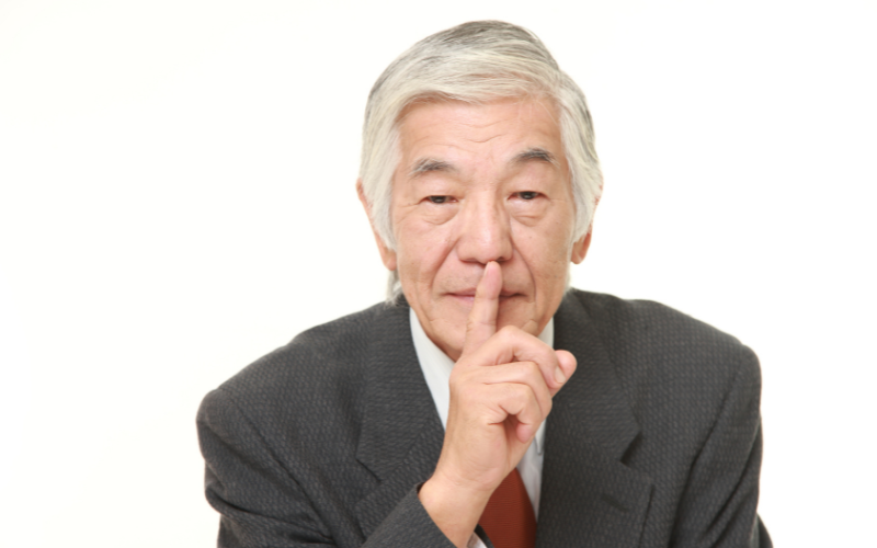 Uomo giapponese che fa il gesto del silenzio: simbolo di discrezione e rispetto nella cultura nipponica